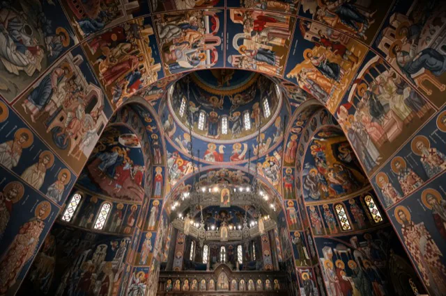 An Orthodox church interior filled with icons and frescoes